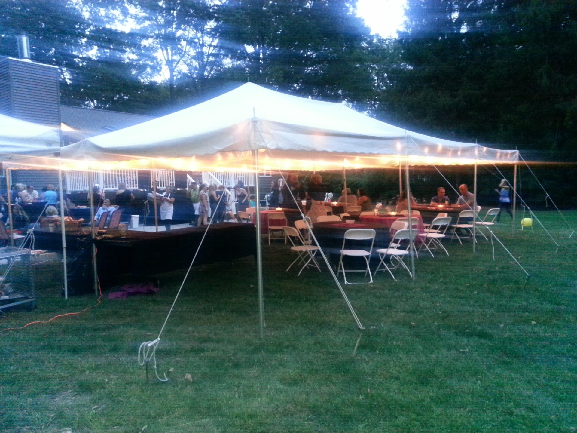A tent with people sitting at the tables.