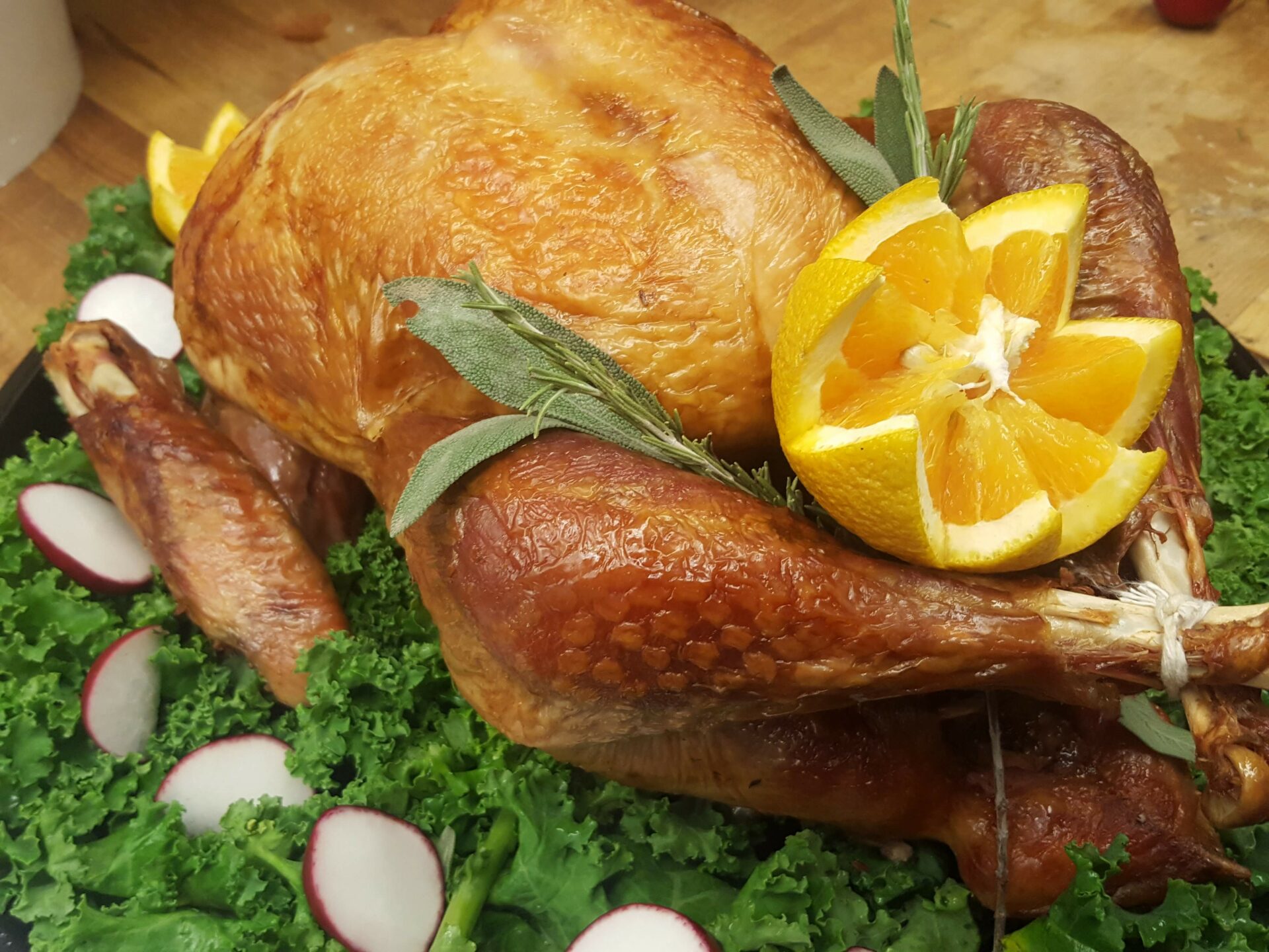 A turkey with orange slices and greens on the side.