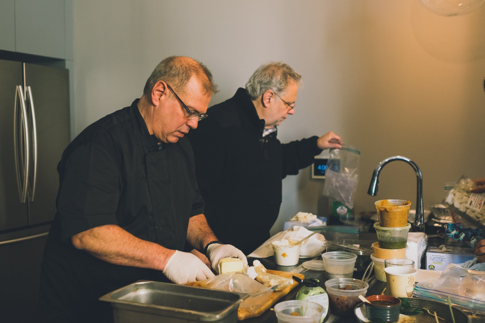Two men are preparing food in a kitchen.